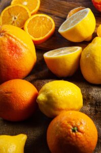 A colorful assortment of fresh citrus fruits including oranges and lemons on a rustic wood background.